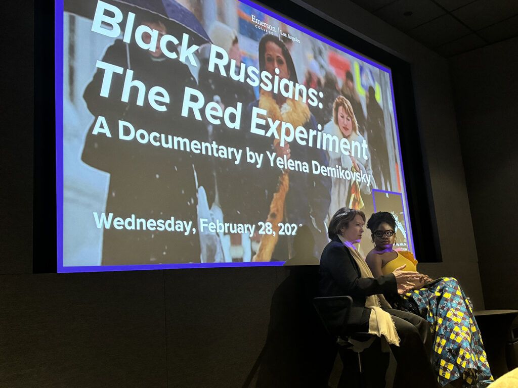 Women sit in front of large screen reading "Black Russians: The Red Experiment"