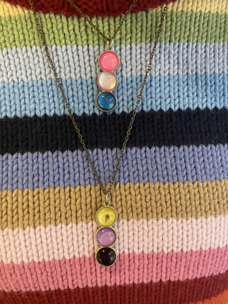 Two colorful necklaces on someone's sweater