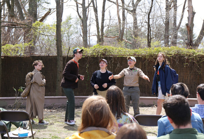 Students perform outside in front of an audience