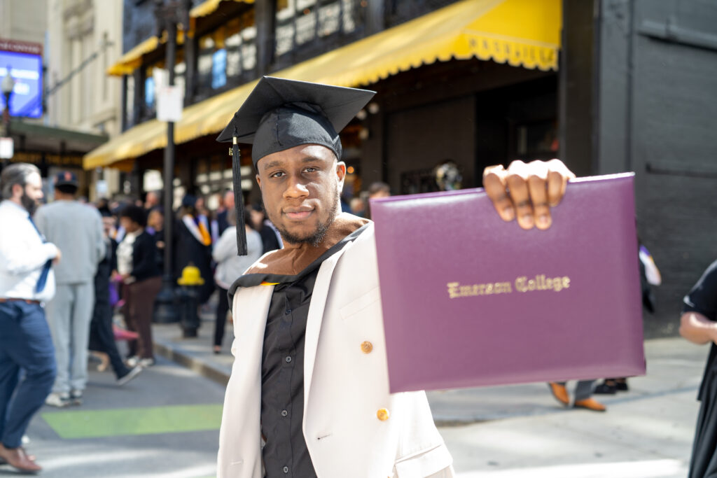 A person holds up his diploma