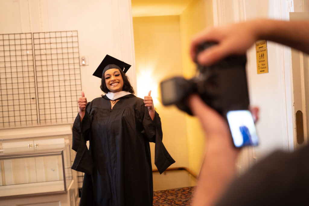 A grad poses while smiling