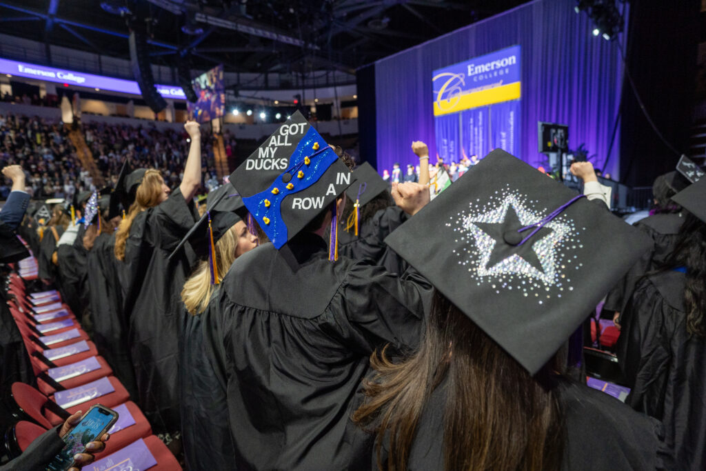 Photo from behind students looking at their mortar boards