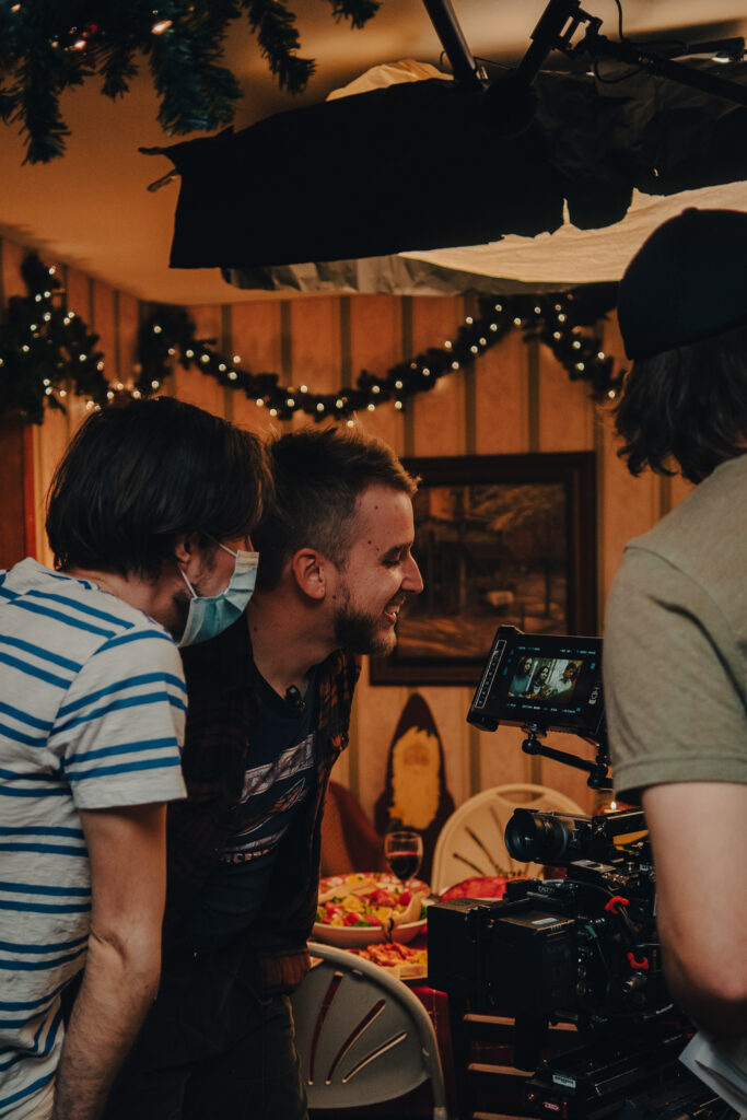 Carson Lund with two other people looking at the playback after filming a scene