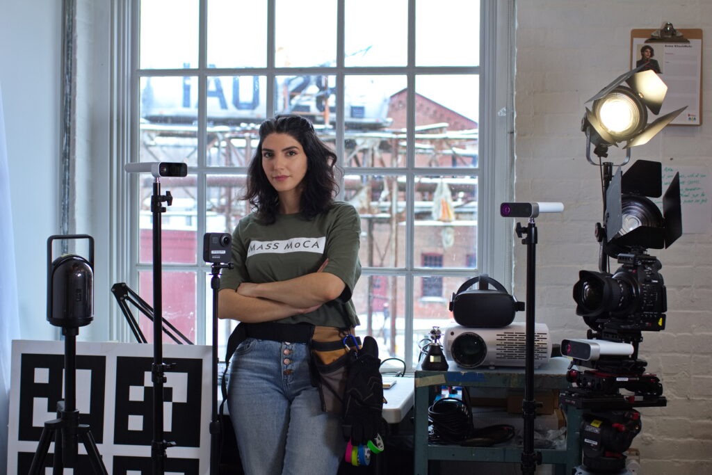Asma Khoshmehr stands in front of film equipment