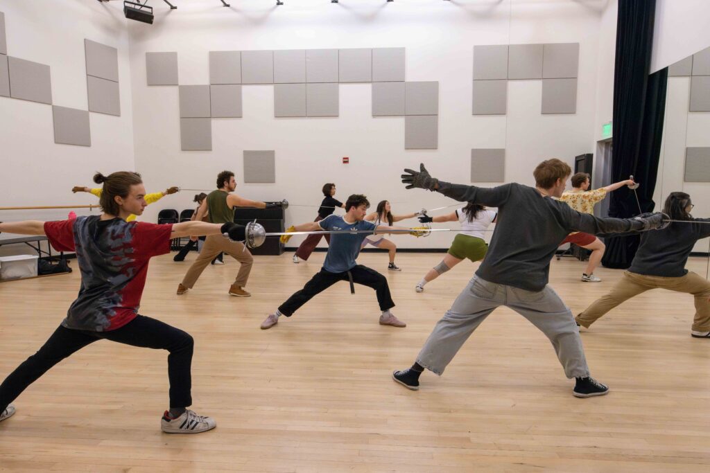 Students practice swordplay in a studio class