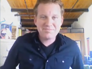 man in navy blue shirt standing in room with wooden ceiling