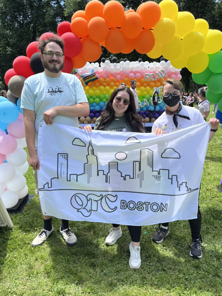 Ben Newman, Hannah McEachern, and Lee Forrest hold a QTCBoston banner