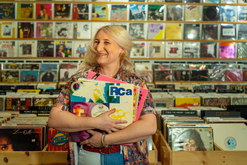 Alexa Lash hugs records in a record store