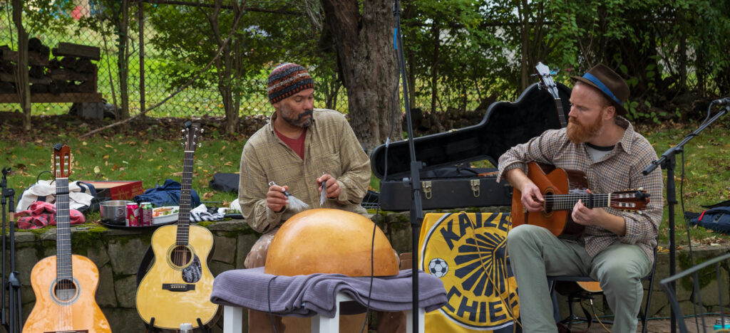 Two guys perform in a band outside