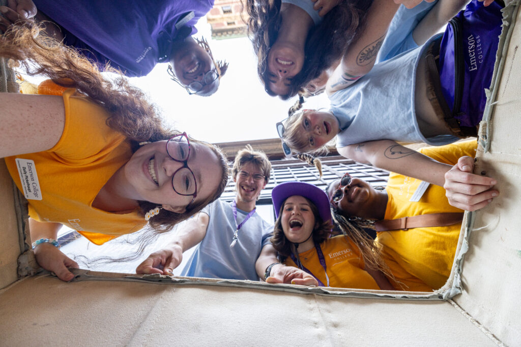 Orientation leaders and coordinators look into a basket with the photographer shooting from in the basket