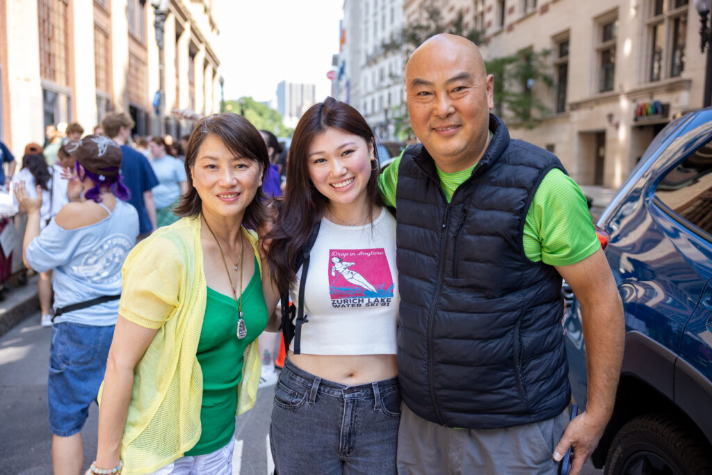 a mother and father with their daughter while she moves into the dorm