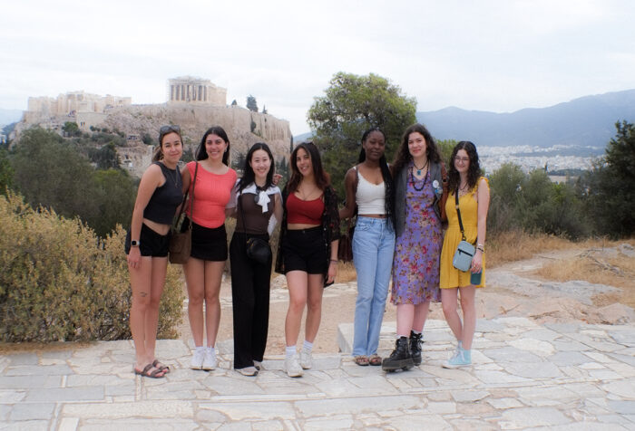 Students stand in Athens with the Parthenon in the background