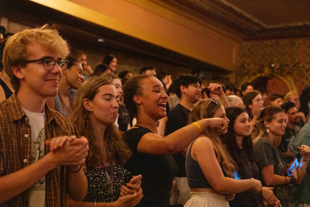 Students laugh, dance, cheer inside theater