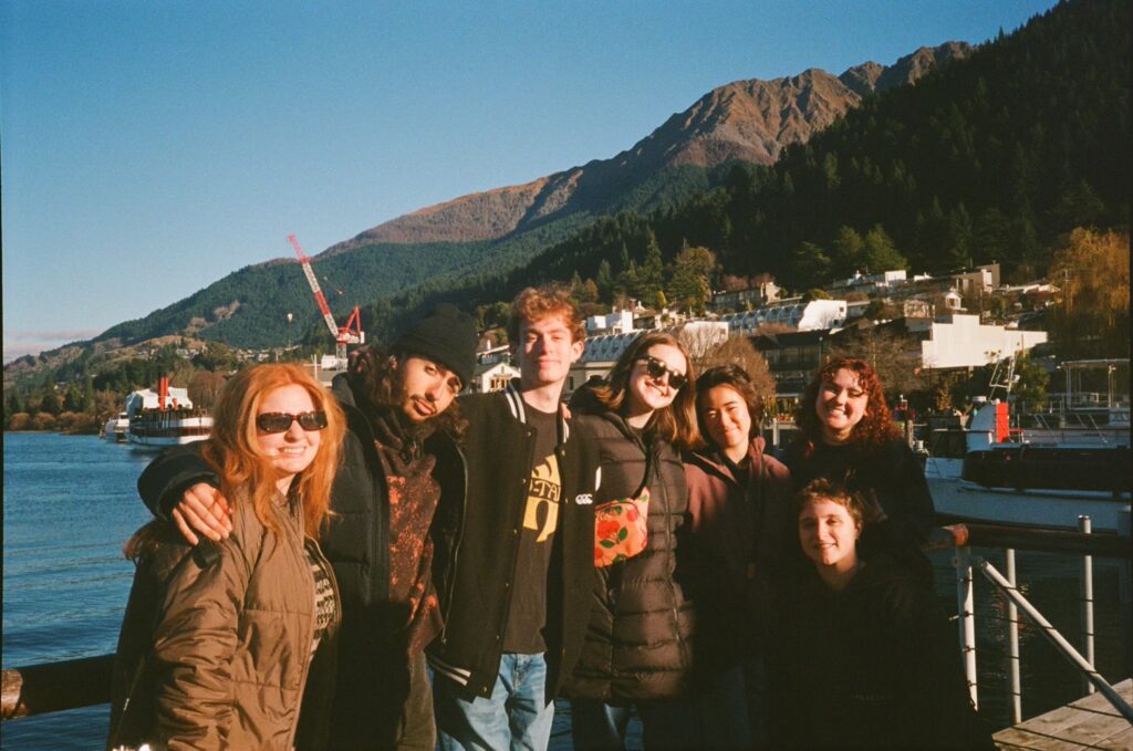 Students pose for a photo in front of a mountain in New Zealand