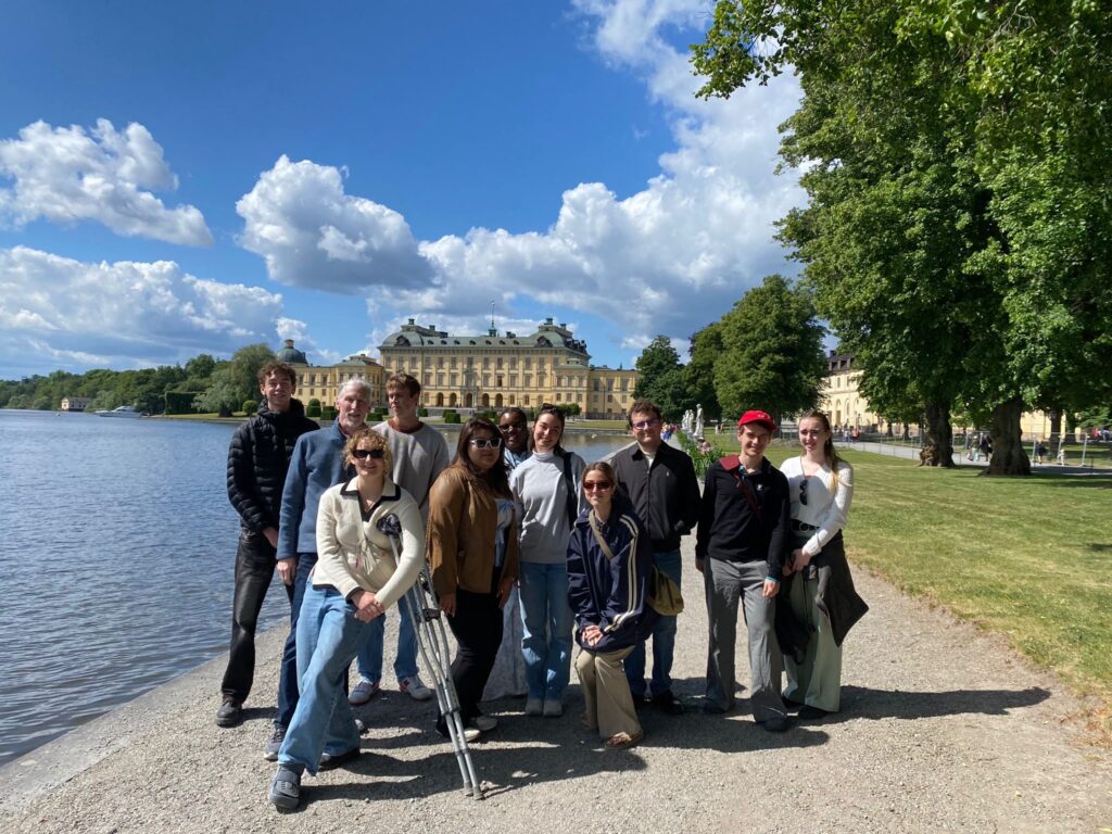 Students and faculty stand in front of Drottningholm Palace in Sweden