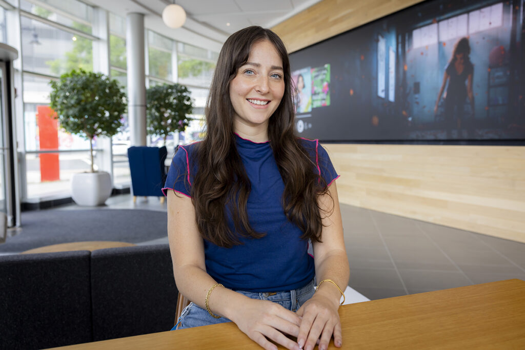 Ashley Rappoport sitting at table in corporate lobby