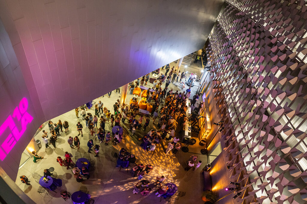 shot from above, looking down through modernist ELA building at crowd milling below