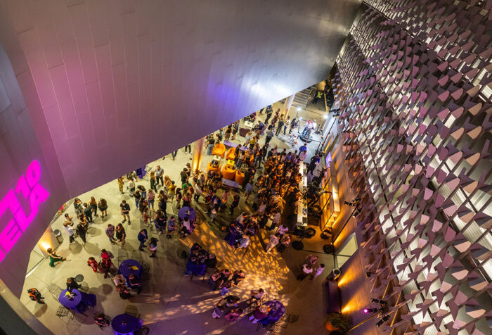 shot from above, looking down through modernist ELA building at crowd milling below