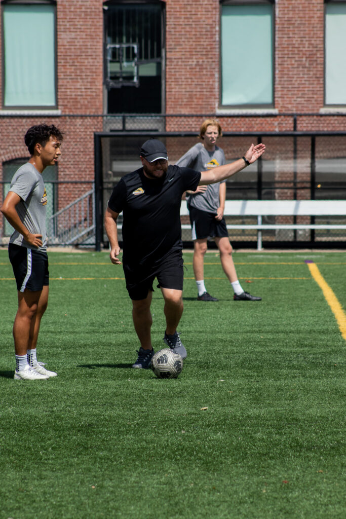 a coach talks to a player on the field