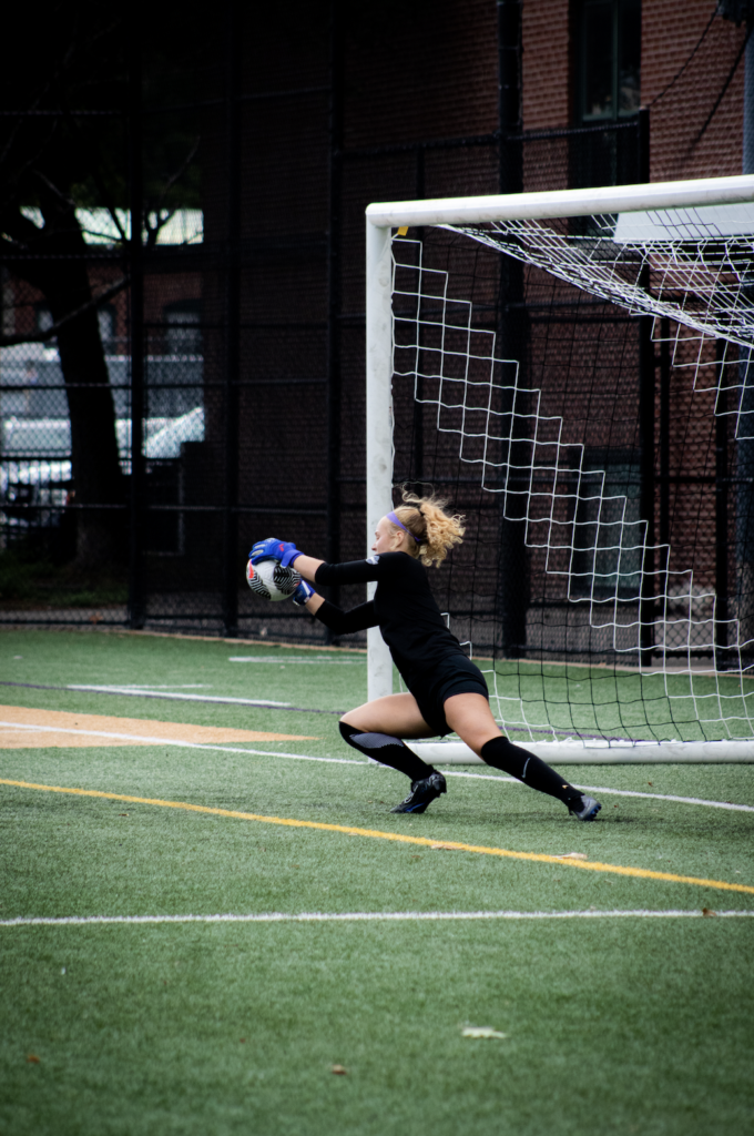 A goalie dives for the ball