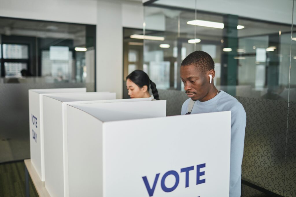 two people vote behind voting booths