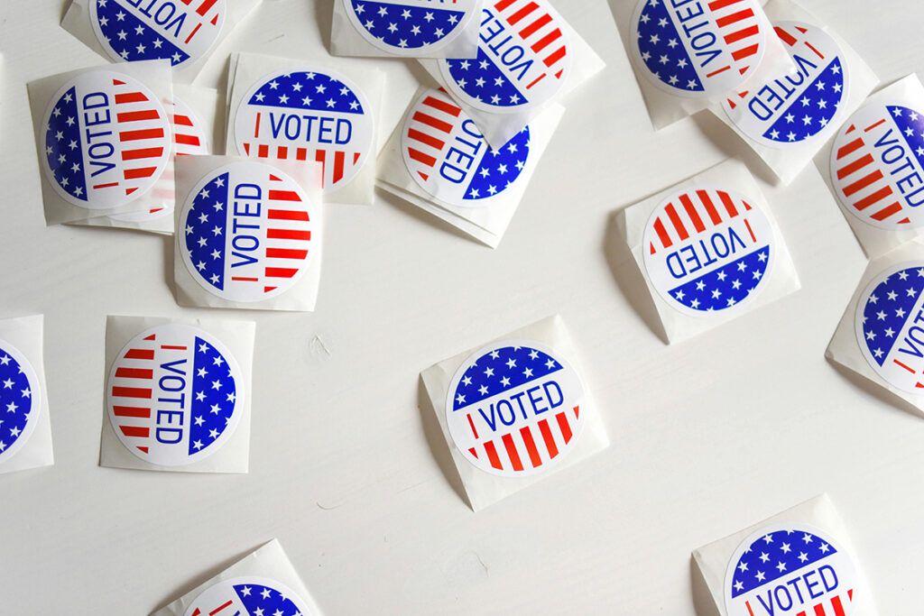 Round stickers that read I voted scattered on a table