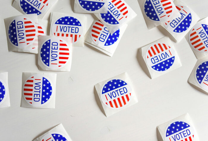 Round stickers that read I voted scattered on a table