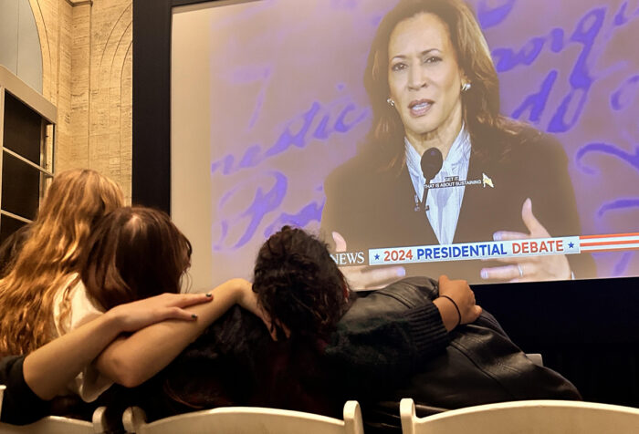 Students watch the presidential debate on a big screen at the Bordy Theatre