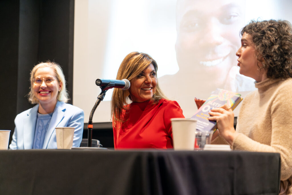 Demi Vitkute, Maria Stephanos and Meghan Keane sit at a dais talking