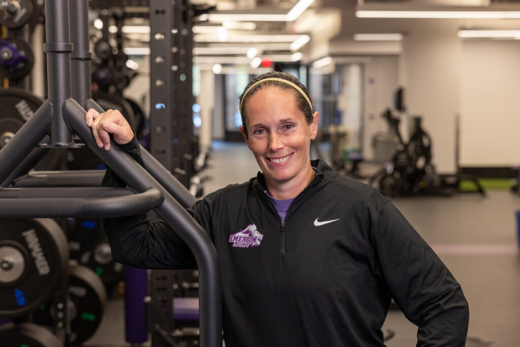 Steph Smyrl leans on workout equipment while posing