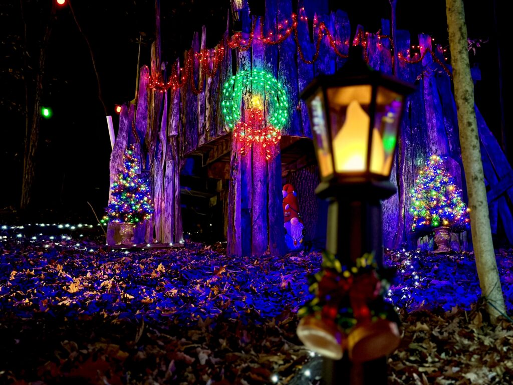 A tent structure is lit up by several different lights with different colors