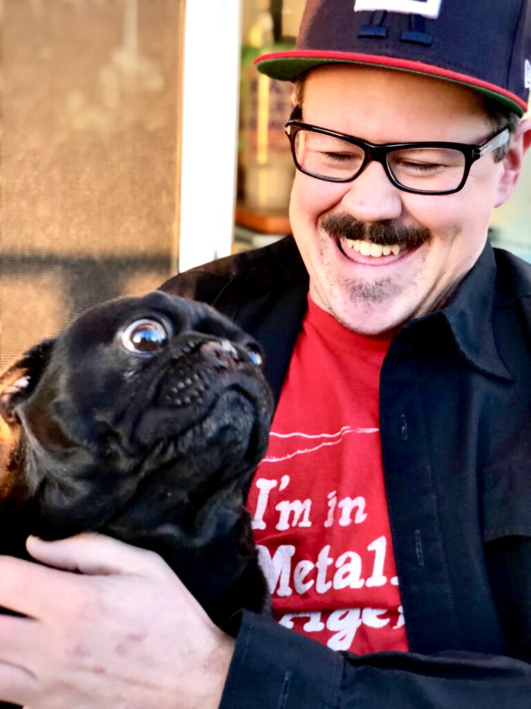 Benjamin McCormick smiling while playing with a dog