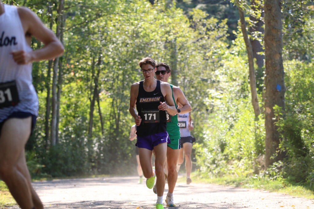 Bryan Hecht runs through the woods in cross country meet