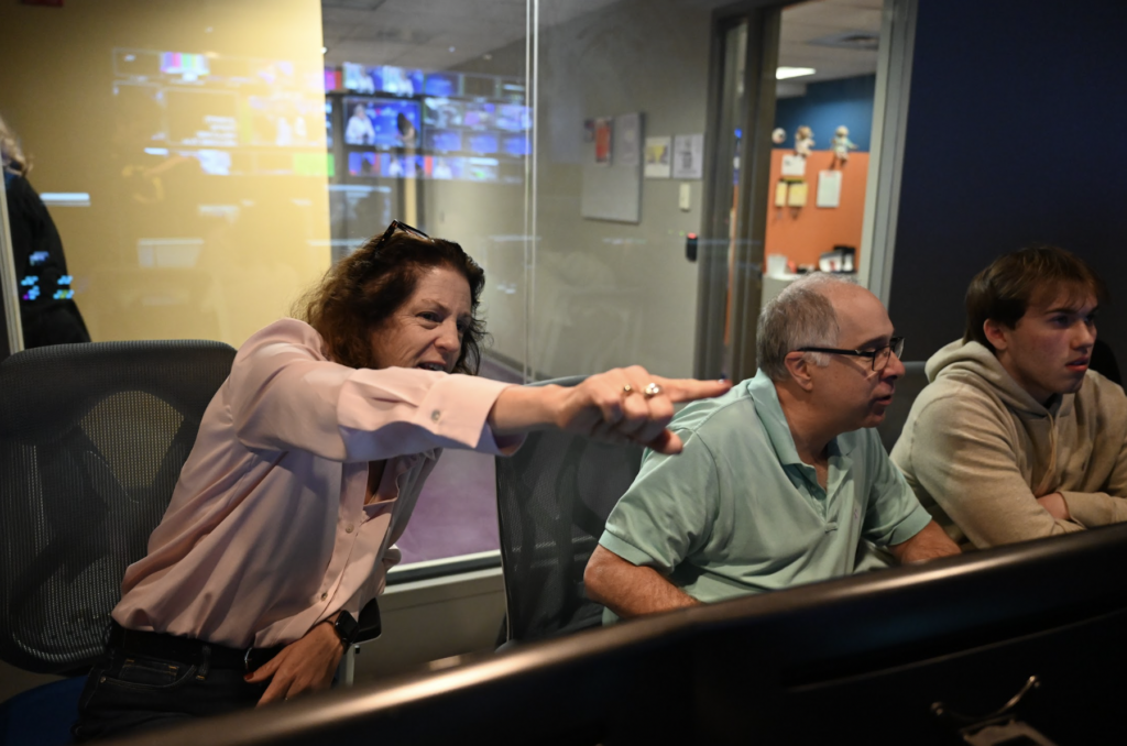 Angela Anderson-Connolly points while Bob Murphy works from the production room.