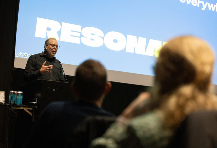 Boaz Paldi stands before screen reading the word "resonate"