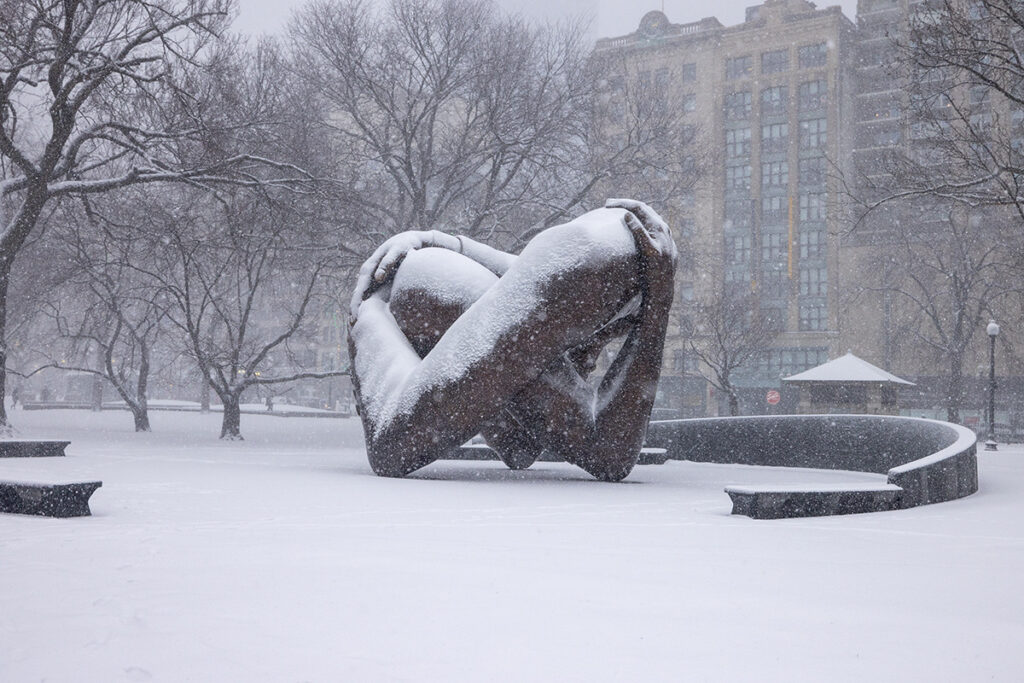 sculpture of arms intertwined, covered in snow