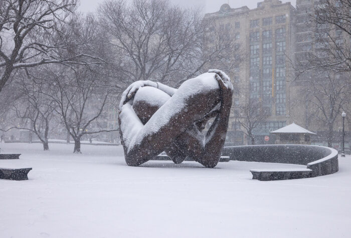 sculpture of arms intertwined, covered in snow