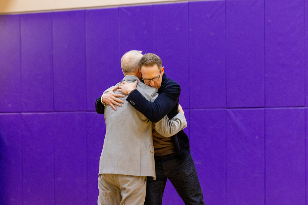 Men in suits hug