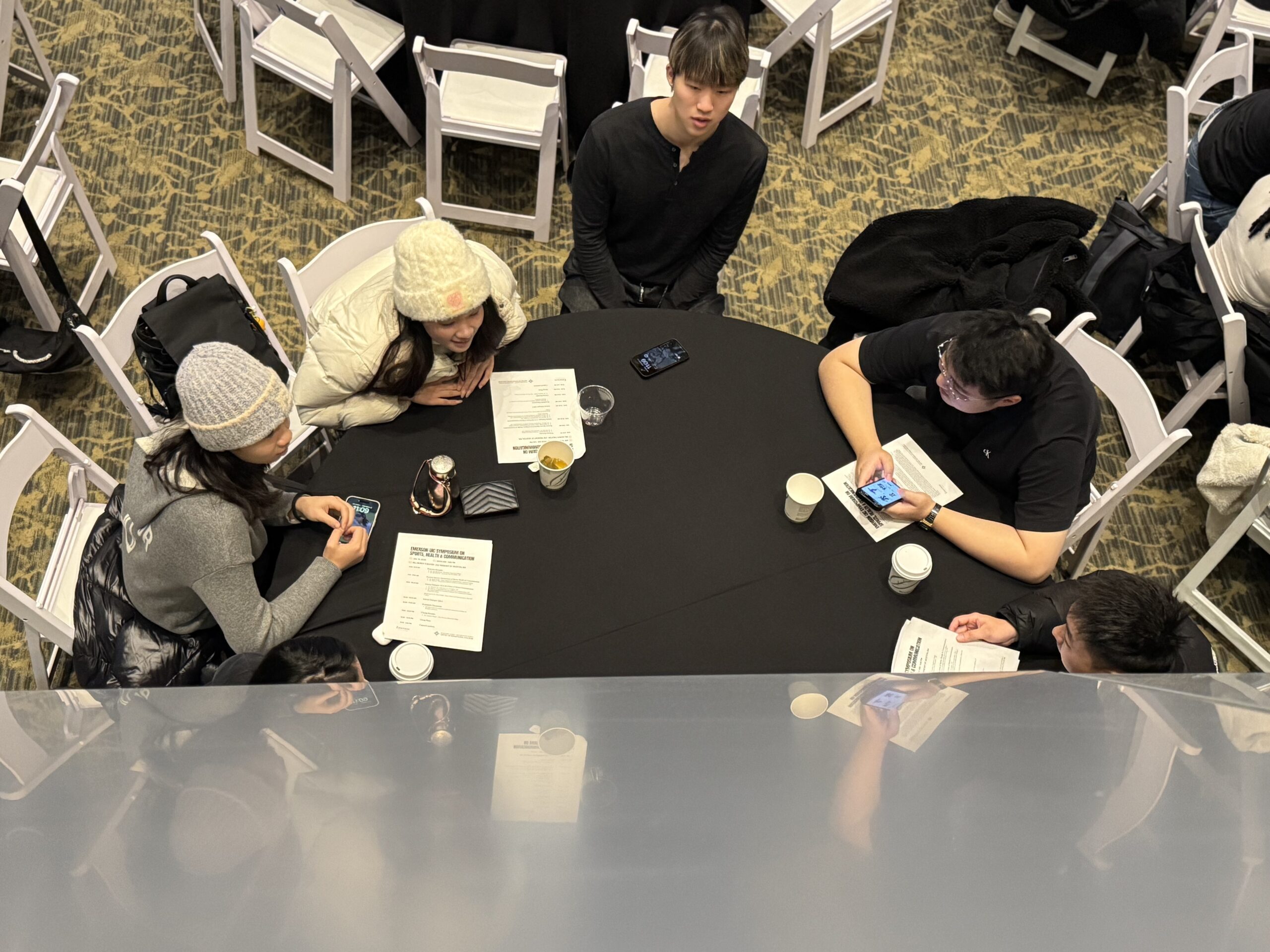 Leaning into a round table as they all sit and talk, Students from UIC and Emerson engage in small-group discussions on the future of sports communication, health, and society. [Photo/Molly Loughman]