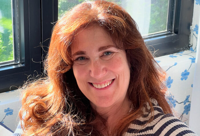 head shot of woman with red hair, striped top