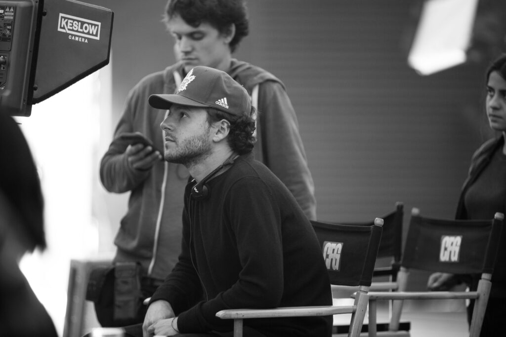 Danny Turkiewicz sits in director's chair looking at playback