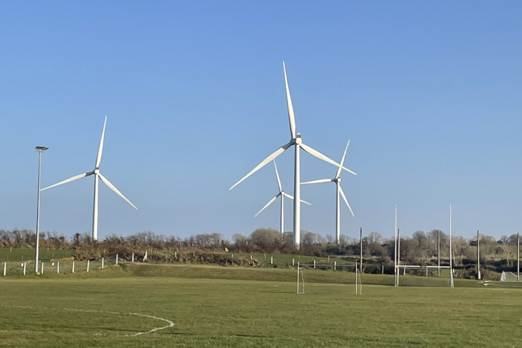 wind turbines tower over a soccer pitch in Ireland