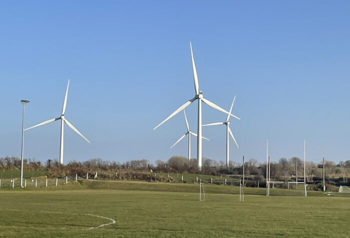 wind turbines tower over a soccer pitch in Ireland