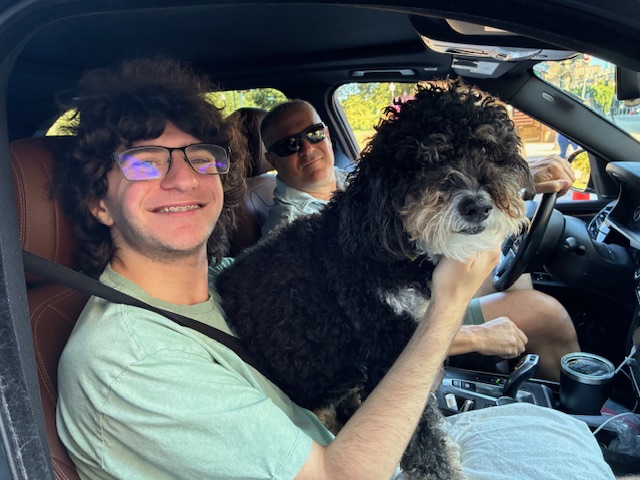 Kyle Katzman with his dad Dan, and their dog Callie, in a car