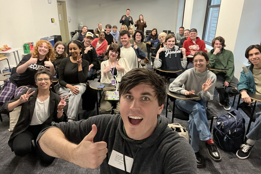 Matt Shearer gives the thumbs up with a class of students behind him