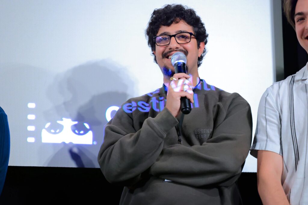 Zaid Sater speaks while holding a microphone