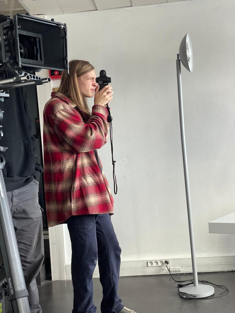 Elijah Stammler holds a camera to his face