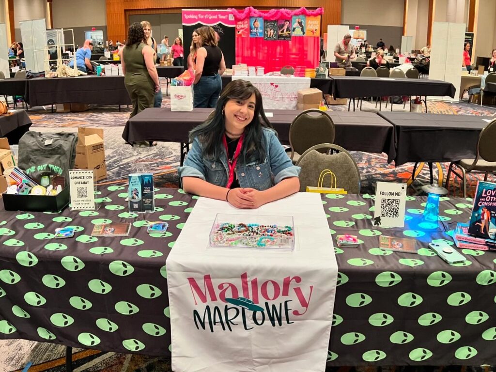 Mallory Marlowe sitting at a table for a book signing