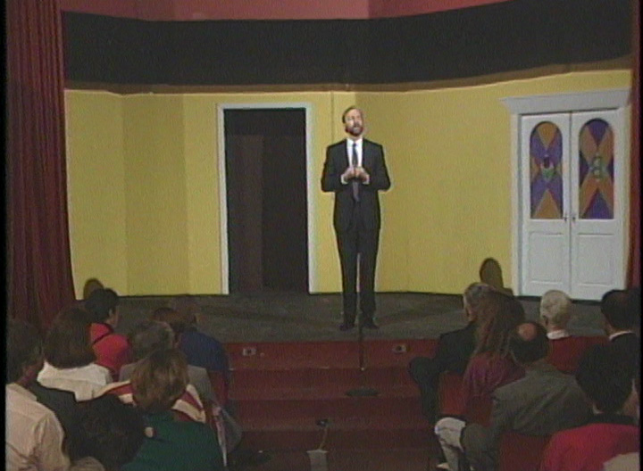 Neil Davin performs on stage in front of an audience