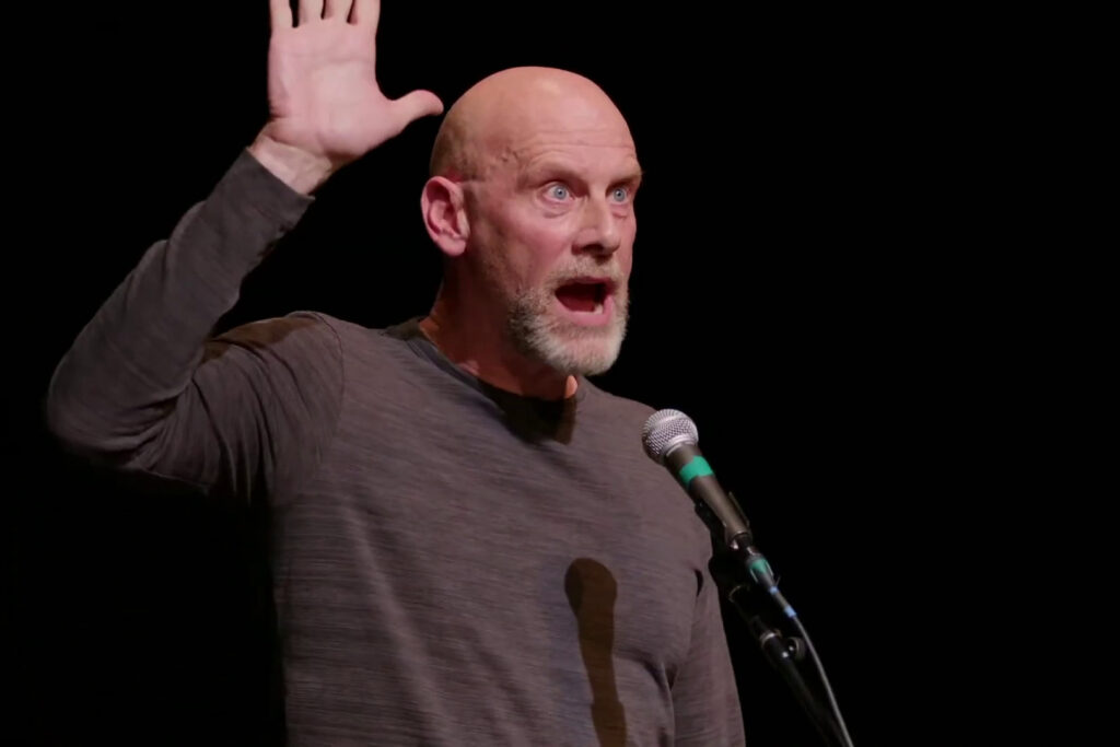 Kenneth Grout raises his hand while performing
